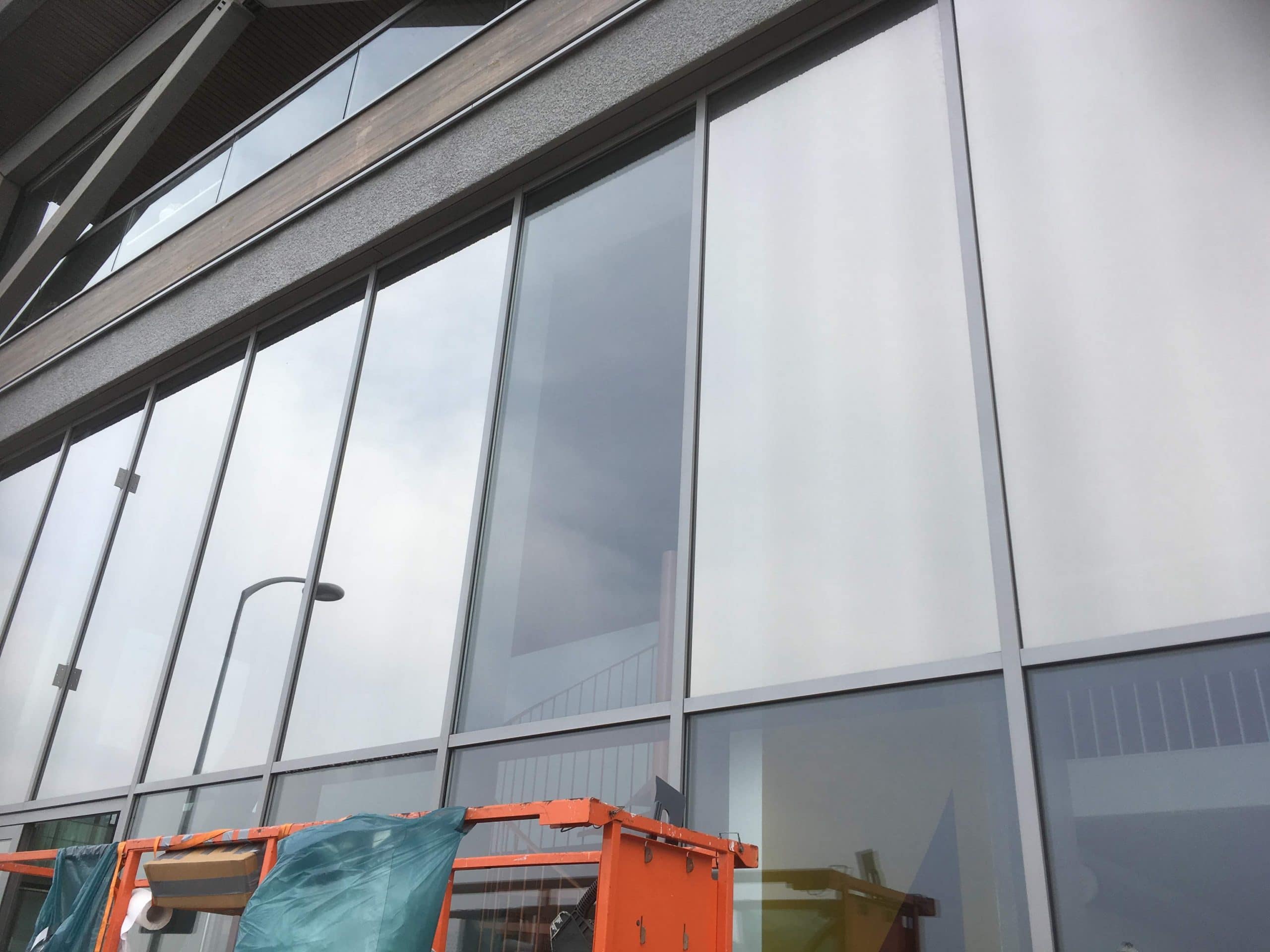 Amsterdam - Sunblock Stainless Steel 25 gemonteerd op de ramen van een bedrijfsruimte om de overmatige zonnewarmte buiten te houden en de hinderlijke schittering te verminderen