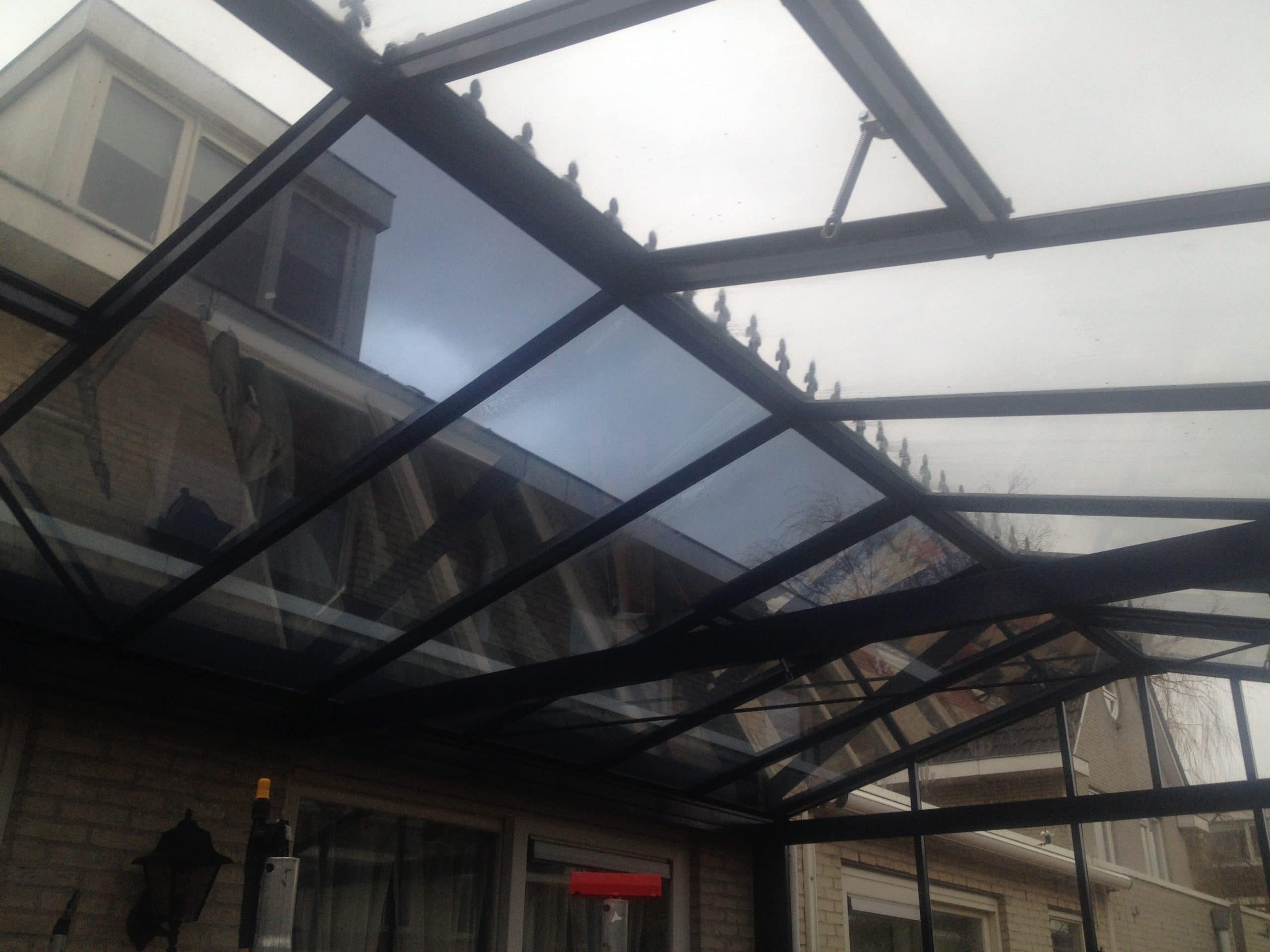 Sunblock Zilver 20 gemonteerd op het glazen dak van een binnentuin - reductie van de zonnewarmte tot 70%